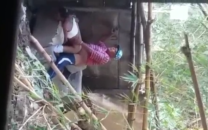 graban al abuelo cogiendose a una nieta entre las hierbas